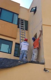 pintor de casas pintando la pared exterior de una casa