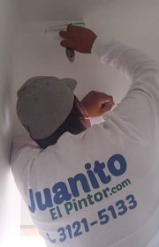 pintor de casas pintando de blanco el techo de una habitación