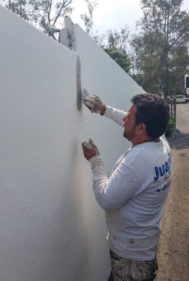 pintor de casas resanando la pared de una cochera