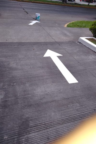 flecha recta blanca pintada sobre asfalto por un pintor de casas