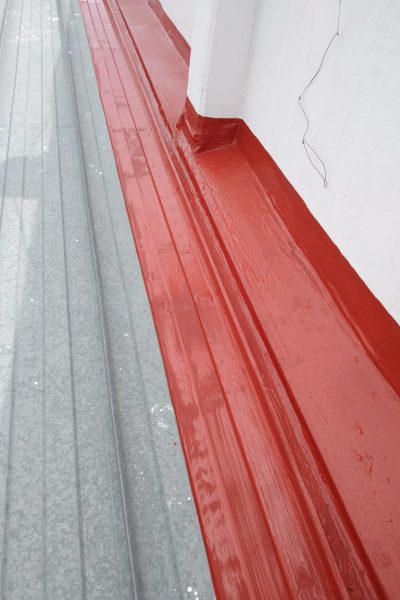 sello de impermeabilizante rojo entre pared de azotea y lámina galbanizada hecho por un pintor de casas